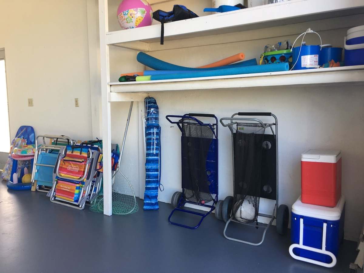 Beach chairs, wagons, noodles, and coolers stored on shelves