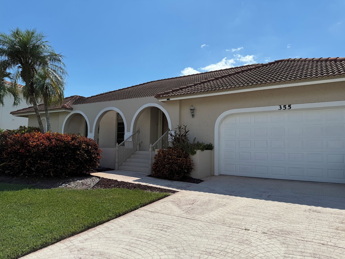 A two-story house with a tiled roof, a garage, and a well-maintained lawn.