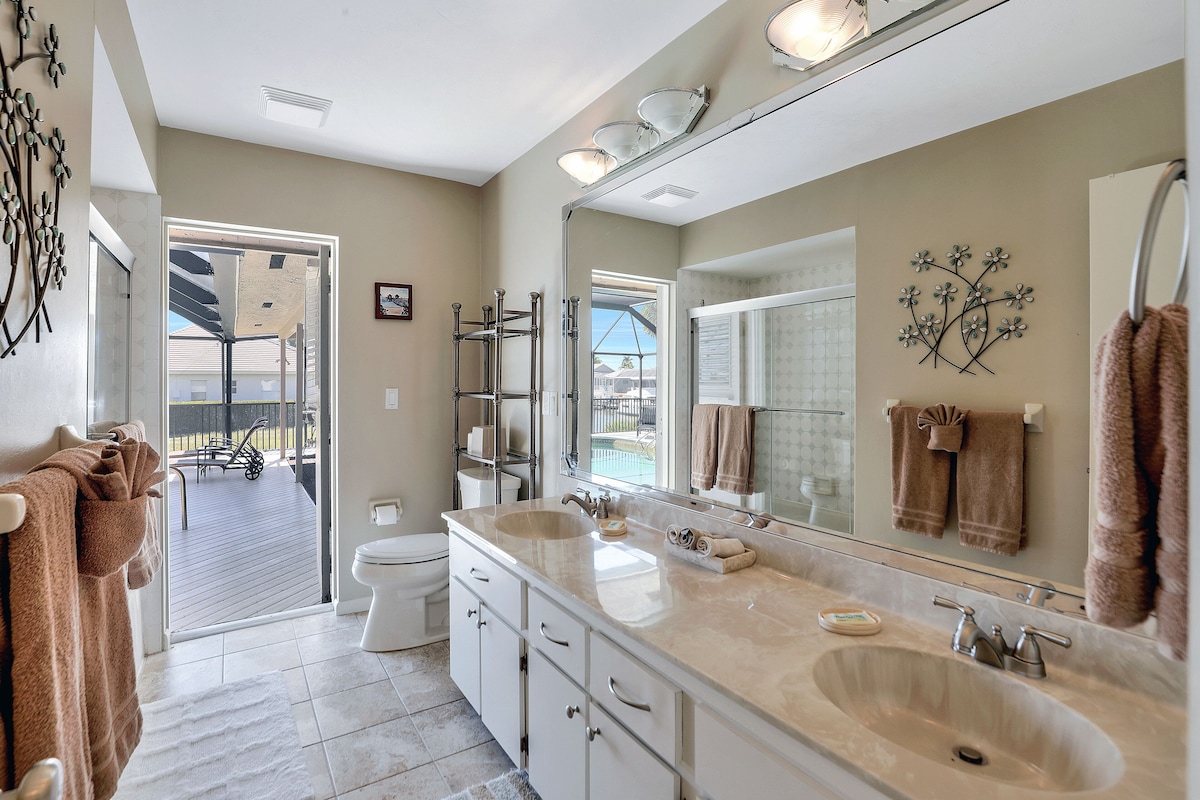 A bathroom with a large sink, mirror, and towel rack.