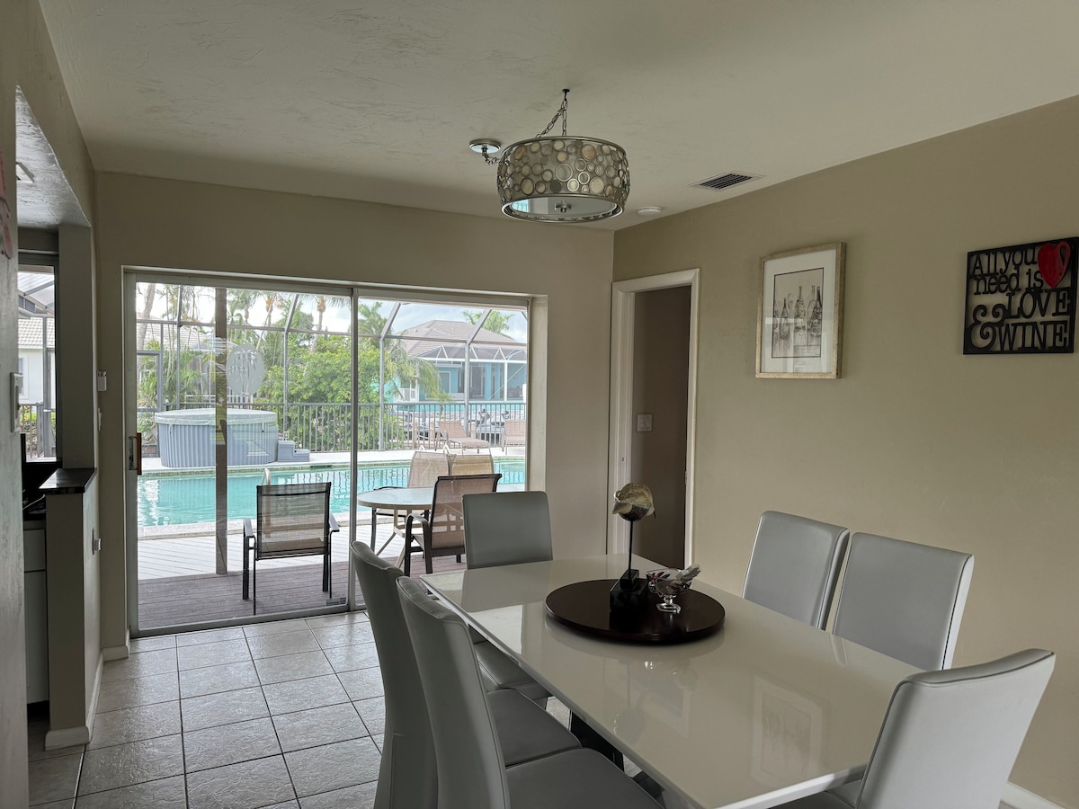 A dining area with a pool view, a chandelier, and a framed picture on the wall.