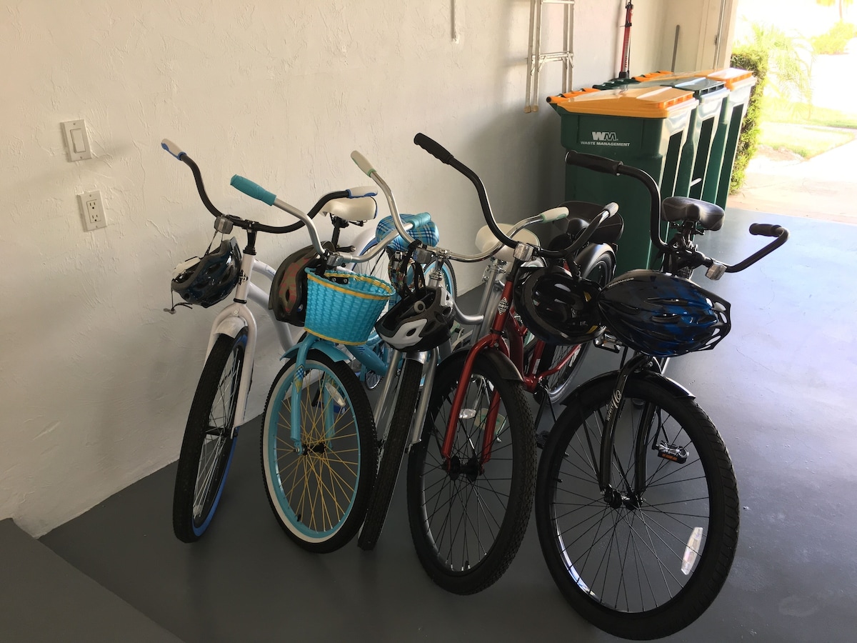A row of bicycles parked against a wall in a garage.