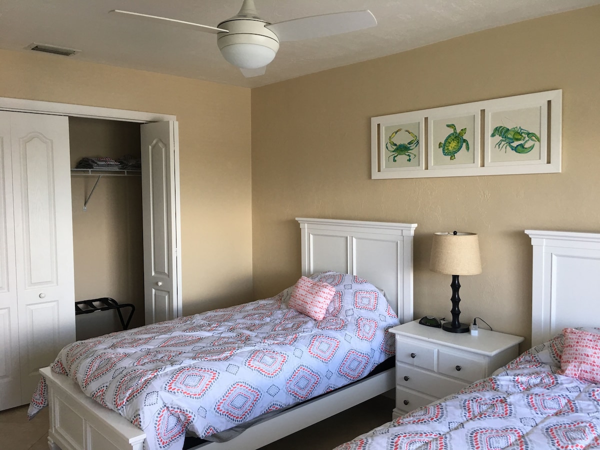 A bedroom with a bed, nightstand, and a ceiling fan.