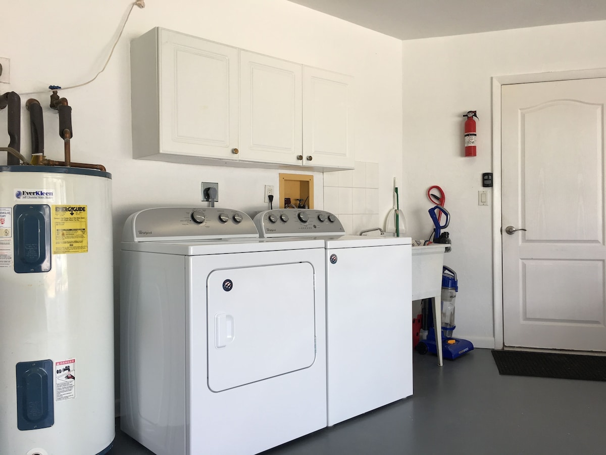 A laundry area with a washer and dryer, a water heater, and a fire extinguisher.